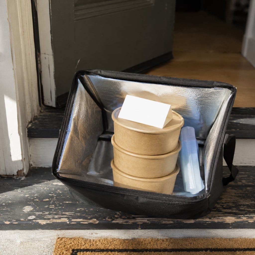 An insulated delivery bag of postpartum meals left on a doorstep